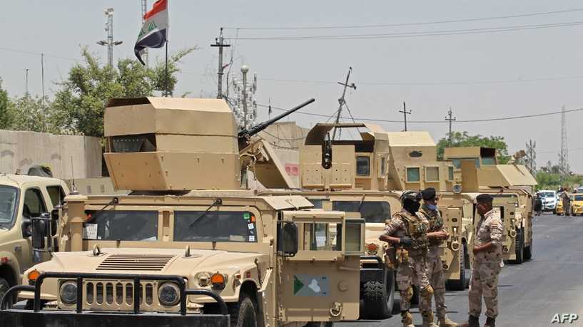 Vehicles of the Iraqi army block the entrance to the capital Baghdad’s suburb of Sadr City on May 21, 2020, during a COVID-19 testing campaign as part of measures taken by the authorities aimed at containing the spread of the novel coronavirus. – Certain neighbourhoods in the Iraqi capital Baghdad began a full lockdown for two weeks as of yesterday, in reaction to a spike in coronavirus infections since restrictions were relaxed. (Photo by AHMAD AL-RUBAYE / AFP)