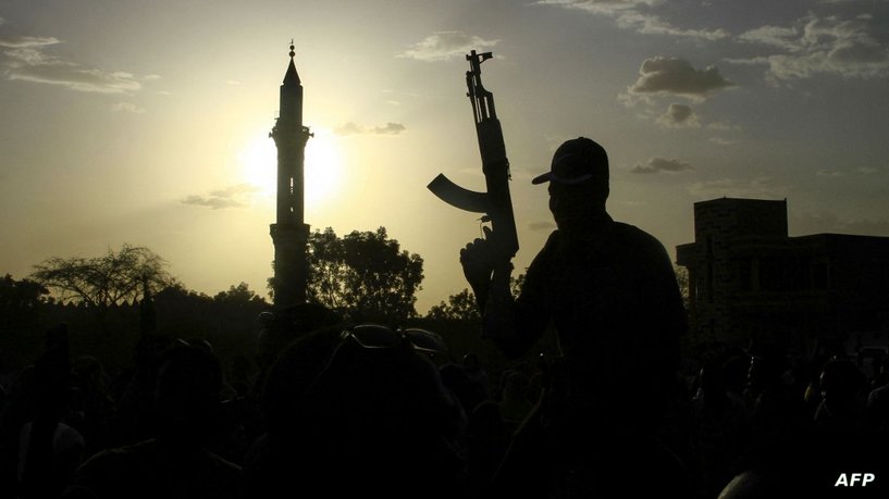 A fighter loyal to Sudan’s army chief Abdel Fattah al-Burhan holds up a weapon backdropped by the minaret of a mosque, during a graduation ceremony in the southeastern Gedaref state on May 27, 2024. Sudan has been in the throes of conflict for over a year between the regular army led by de facto ruler Abdel Fattah al-Burhan and the RSF led by his former deputy Mohamed Hamdan Daglo. (Photo by AFP)