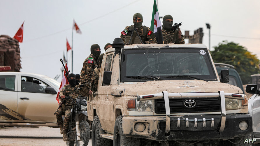 Syrian fighters ride in a convoy during a military drill by the Turkish-backed “Suleiman Shah Division” in the opposition-held Afrin region of northern Syria on November 22, 2022. (Photo by Bakr ALKASEM / AFP)