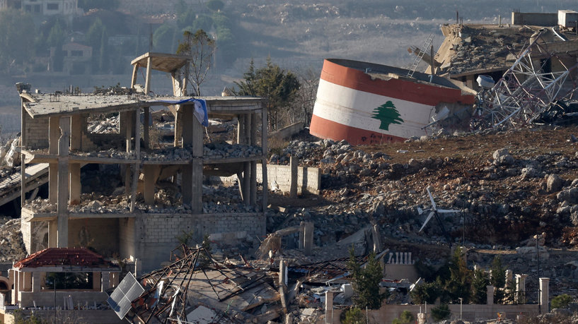 This picture taken from a position in northern Israel, near the border with Lebanon, shows an Israeli flag (L) on a destroyed building, and a Lebanese flag (R) painted on a damaged building in the southern Lebanese village of Meiss El-Jabal on November 25, 2024, amid the ongoing war between Israel and Hezbollah. – Israeli ground forces have entered several villages and towns near Lebanon’s southern border, including Khiam, where the Lebanese National News Agency (NNA) on November 25 reported clashes with Hezbollah fighters. In Mais al-Jabal, more than 1,000 buildings have been hit, according to the mayor of the village which counted some 30,000 residents before the conflict. (Photo by Jalaa MAREY / AFP)