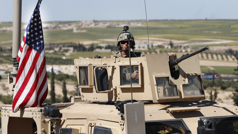 A U.S. soldier sits in an armored vehicle on a road leading to the tense front line with Turkish-backed fighters, in Manbij, north Syria, Wednesday, April 4, 2018. President Donald Trump expects to decide “very quickly” whether to remove U.S. troops from war-torn Syria, saying their primary mission was to defeat the Islamic State group and “we’ve almost completed that task.” (AP Photo/Hussein Malla)