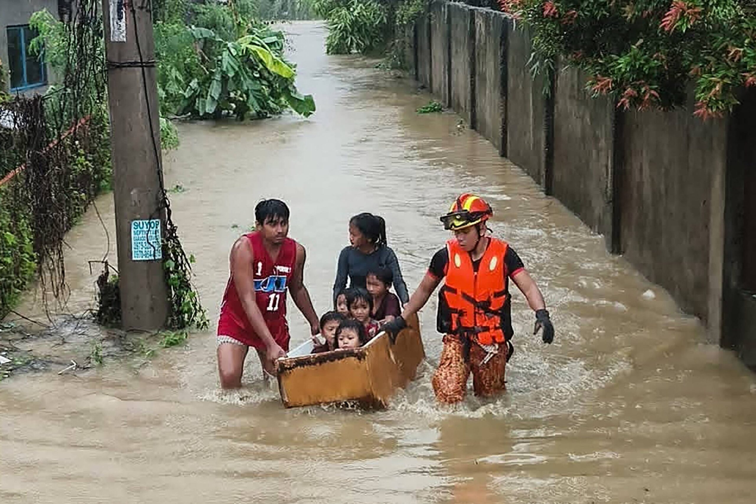 This handout photo taken and released on November 4, 2025 by the Bureau Fire Protection-Toledo City station shows personnel help evacuate people on a makeshift boat made from a discarded refrigerator from their flooded homes following heavy rains brought about by Typhoon Kalmaegi in Toledo City, Cebu province, central Philippines. Residents sought refuge on rooftops and cars floated through flooded streets on November 4 as Typhoon Kalmaegi battered the central Philippines, leaving at least two people dead. (Photo by Handout / BUREAU OF FIRE PROTECTION-TOLEDO CITY / AFP) / RESTRICTED TO EDITORIAL USE – MANDATORY CREDIT “AFP PHOTO / BUREAU OF FIRE PROTECTION-TOLEDO CITY” – HANDOUT – NO MARKETING NO ADVERTISING CAMPAIGNS – DISTRIBUTED AS A SERVICE TO CLIENTS